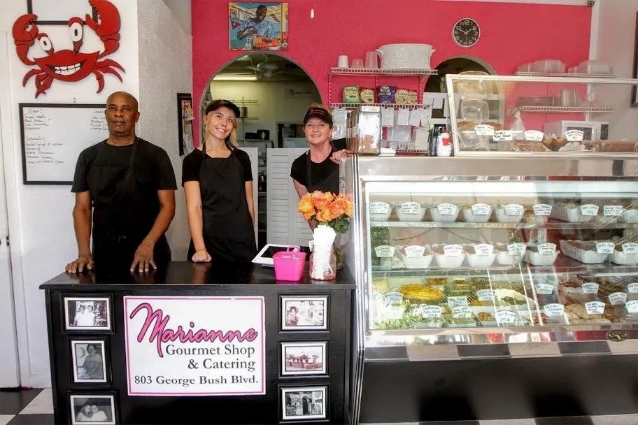 The Marianne Gourmet Shop team behind the counter and the deli case